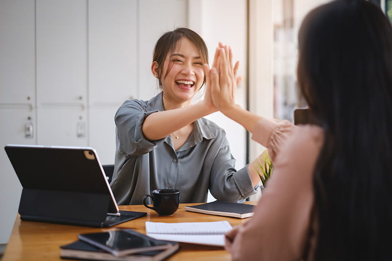 2 employees high-fiving